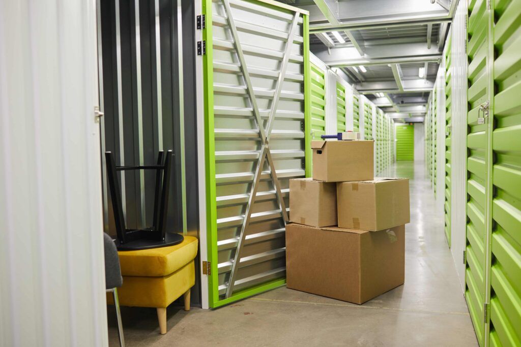 Guardamuebles, con cajas en la puerta y mobiliario en el interior.